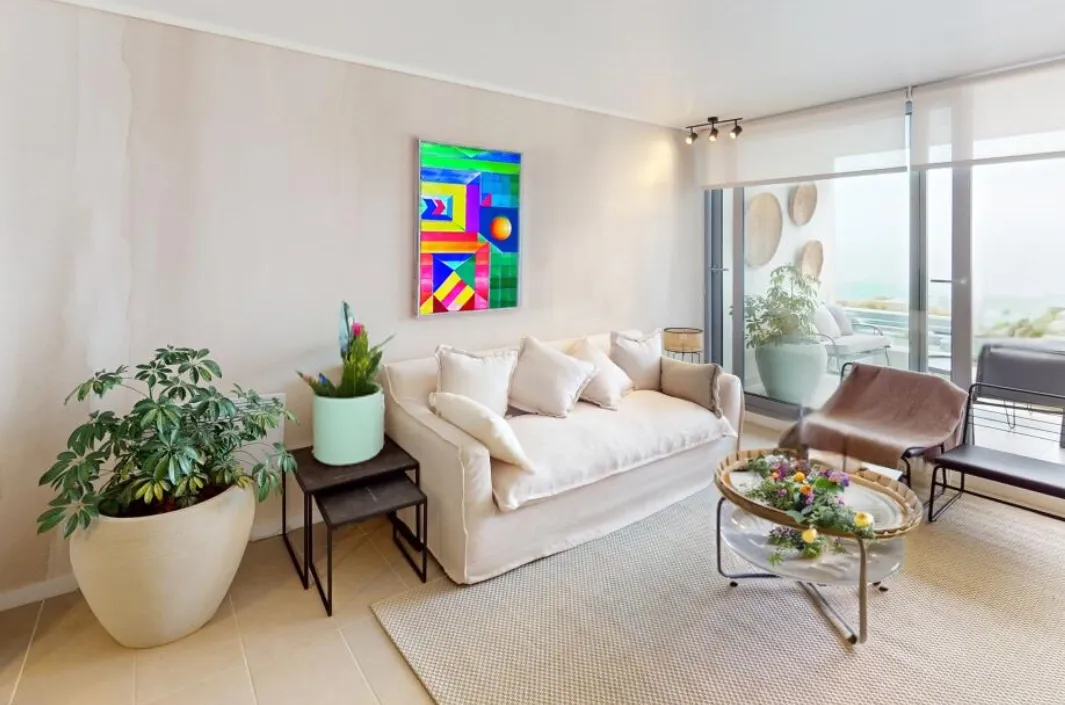 Salon interior con cuadro colorido y muebles beige